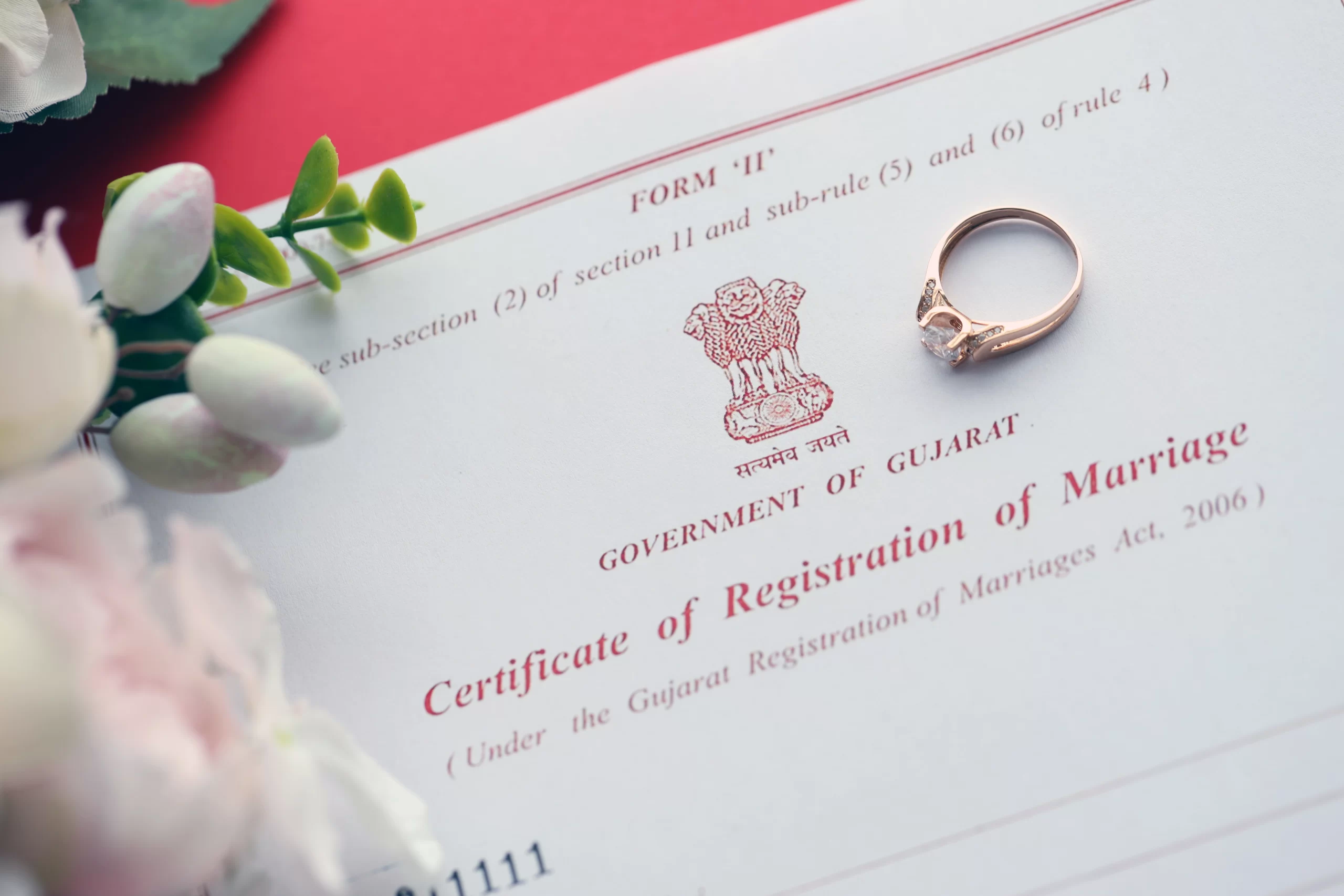 Indian Certificate of Registration of Marriage from the Government of Gujarat with a wedding ring placed on it